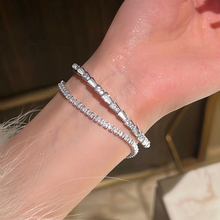 Un diseño de nicho con una pulsera de textura de diamante brillante con apertura en forma de serpiente con piedra de ojo de gato de alta gama, ligera para mujer.