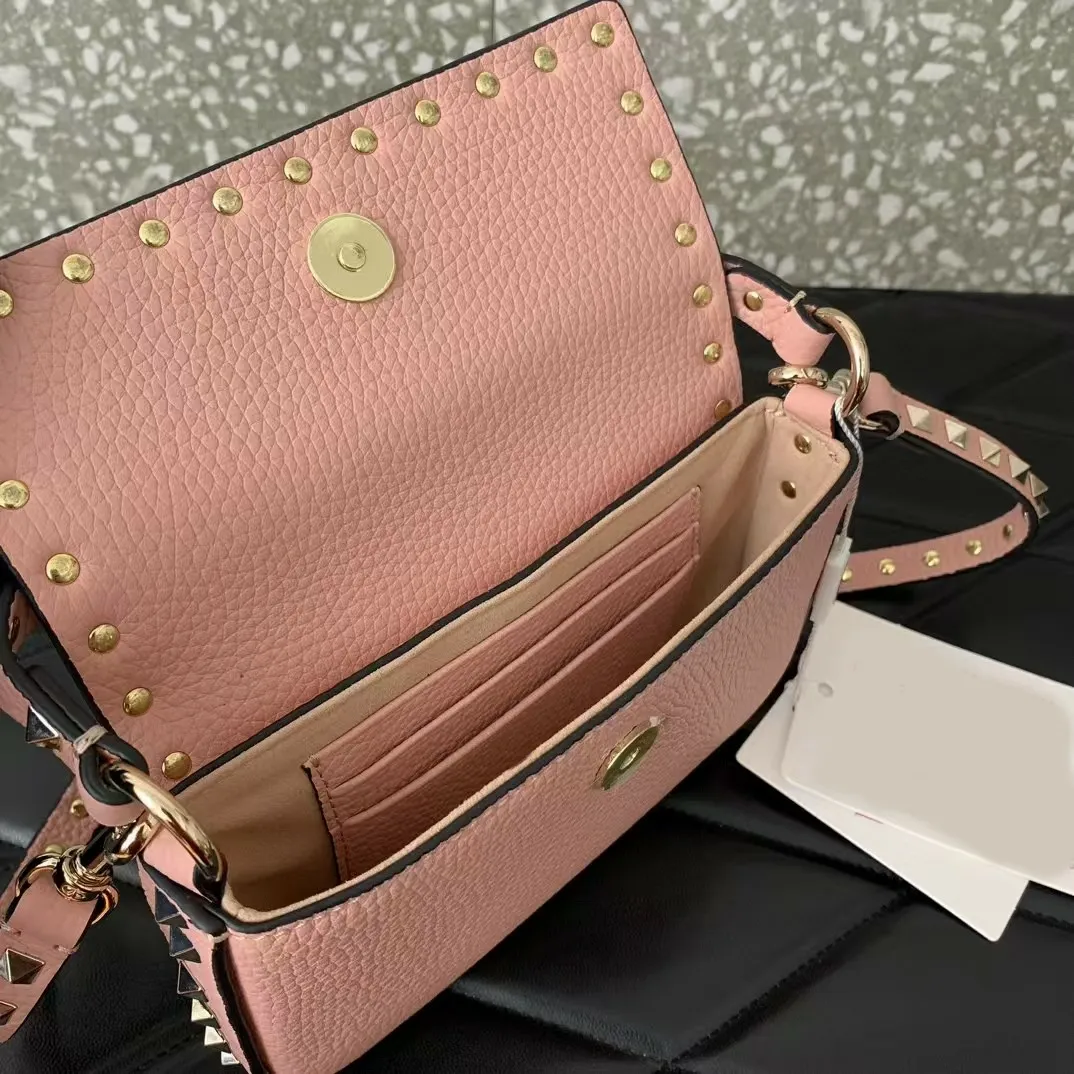 Borsa a tracolla con tracolla lunga in vera pelle di vitello con borchie e fibbia in argento._voghion.com