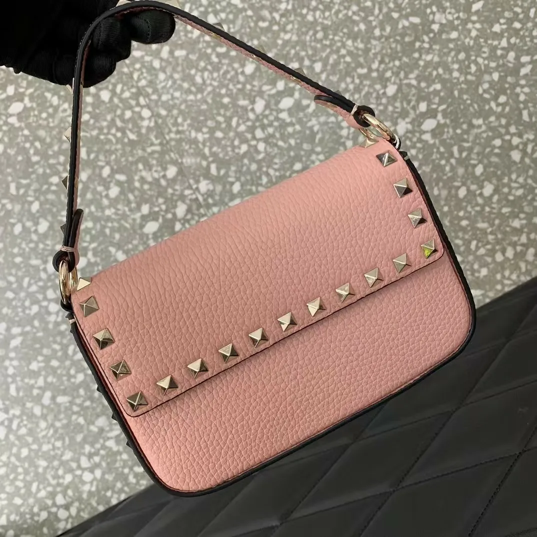 Borsa a tracolla con tracolla lunga in vera pelle di vitello con borchie e fibbia in argento._voghion.com