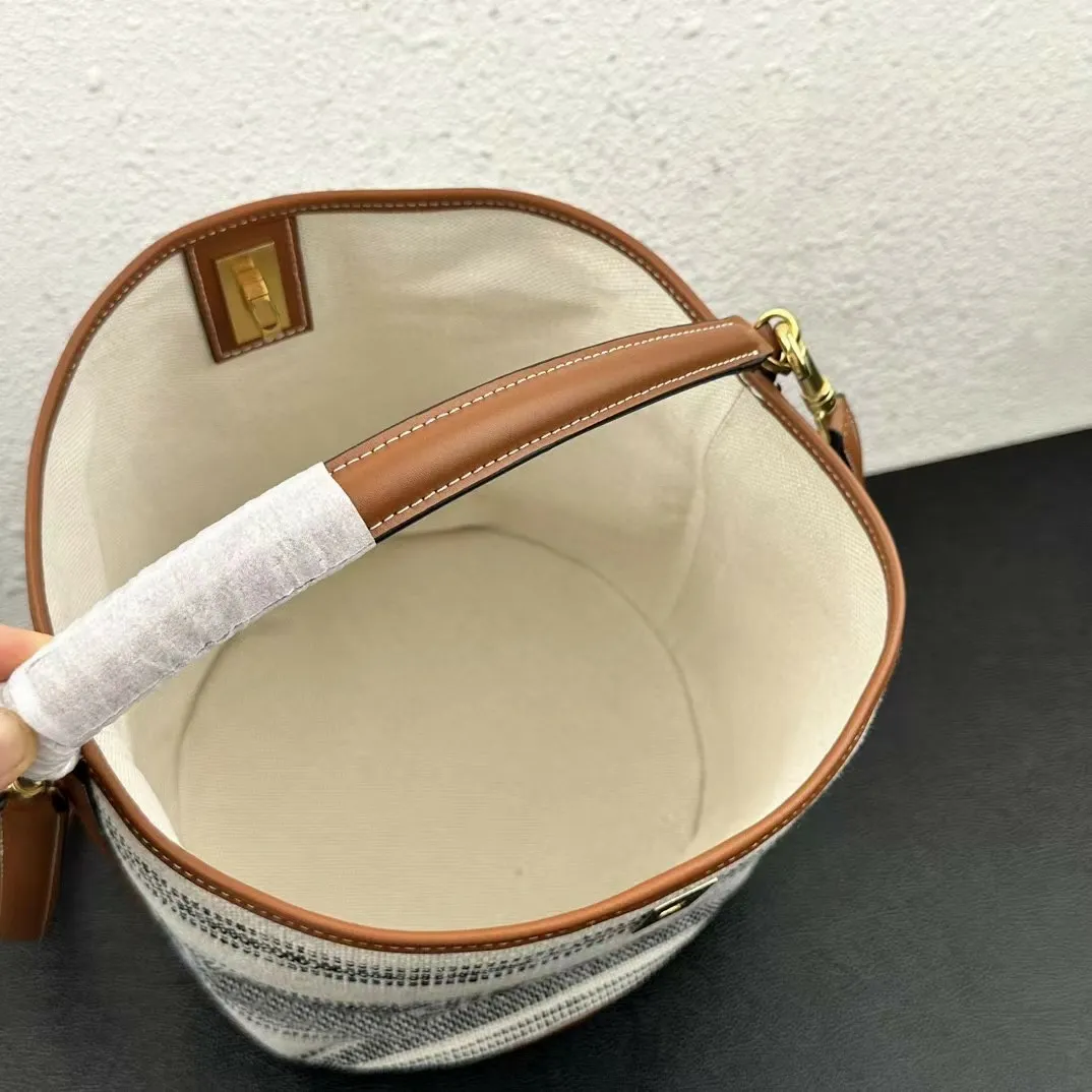 Borse firmate grigie: borsa a secchiello in tela a righe con dettagli in pelle e tracolla lunga regolabile_voghion.com
