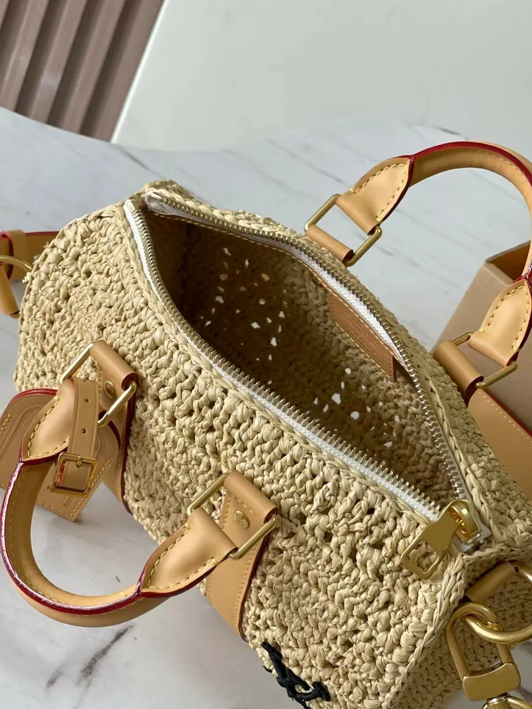 Borse da spiaggia di design di alta qualità in foglia di palma intrecciata, traforate, in rafia e pelle, con tracolla lunga e finiture dorate._voghion.com